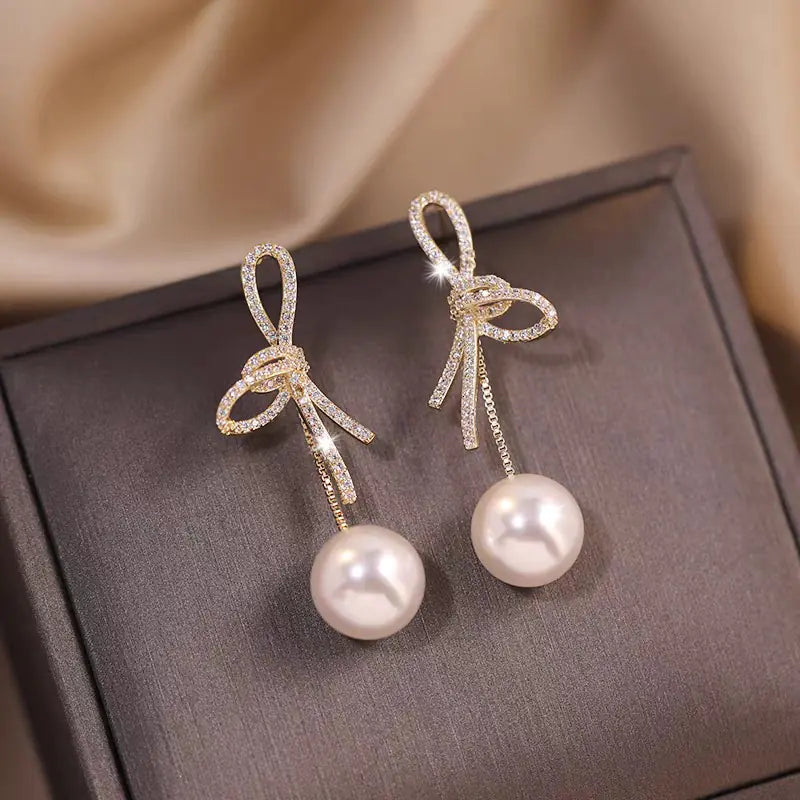 Elegant Bow Pearl Drop Earrings for Women showcasing classic pearl drops and delicate bow design.
