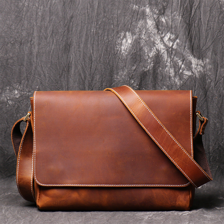 Vintage handmade men's leather crossbody bag with adjustable strap and front pocket, showcasing rich brown texture.
